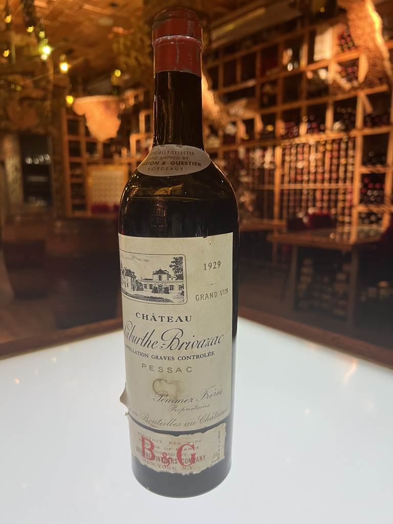 A bottle of wine on a table  Description automatically generated