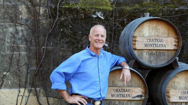 A person standing next to barrels  Description automatically generated