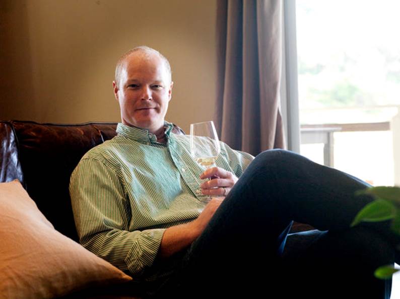 Kirk sitting and holding glass of wine