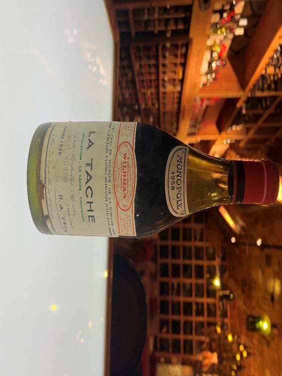 A bottle of wine on a table  Description automatically generated