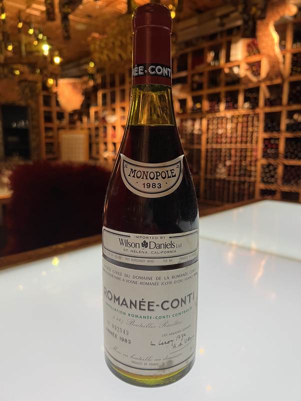 A bottle of wine on a table  Description automatically generated with low confidence